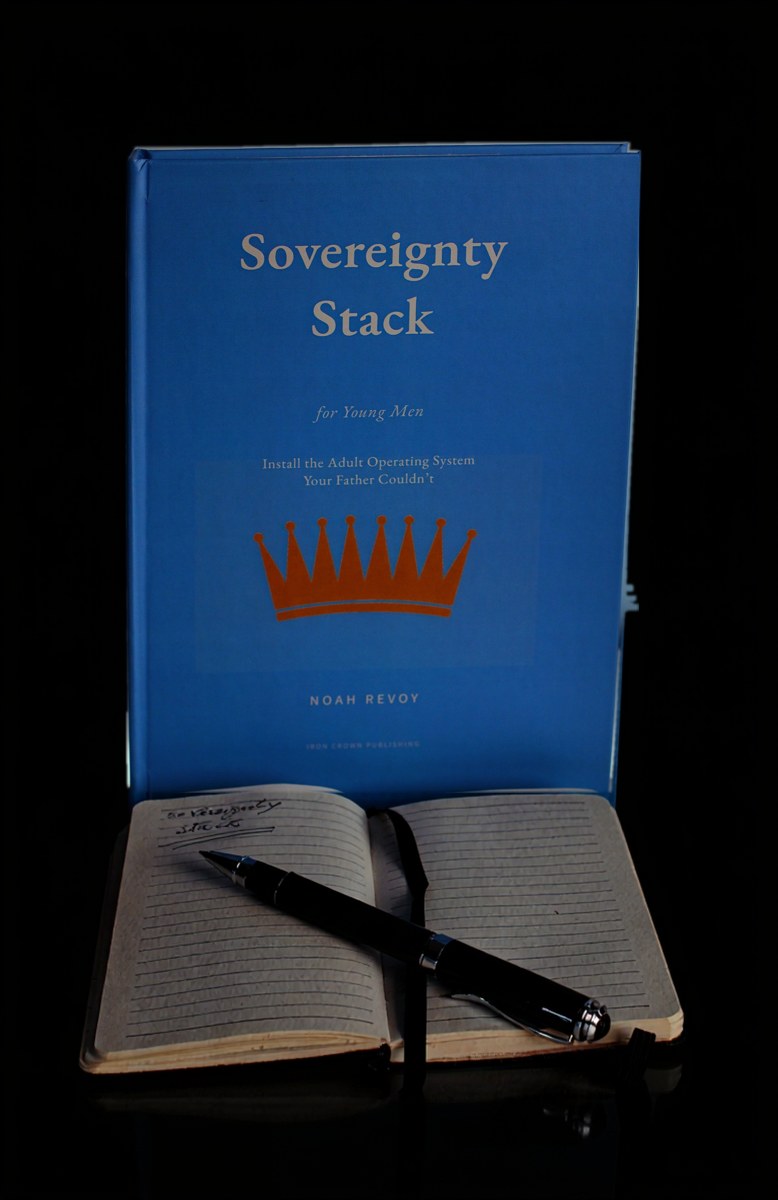 The hardcover photographed on a dark ground beside a notebook.
